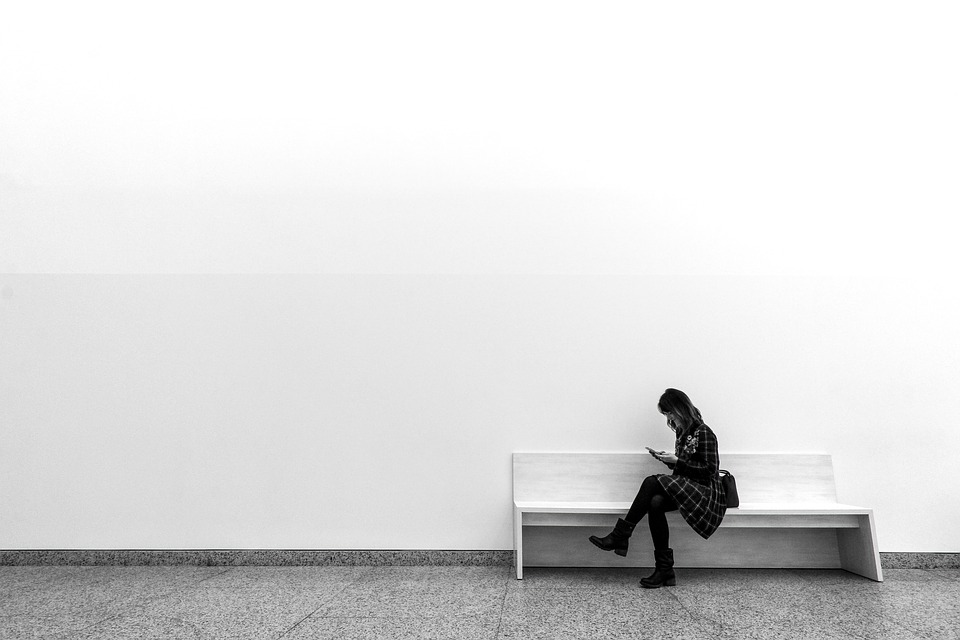 A woman sitting on a bench in a museum. | Places to visit in Bentonville, AR.