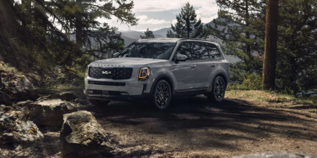 A silver 2022 Kia Telluride parked in a wooded area. | Kia dealer in Bentonville, AR
