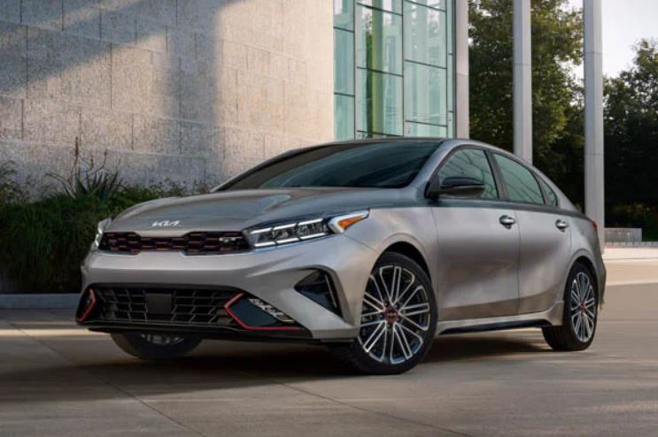 Front view of a silver 2022 Kia Forte parked in front of a building. | Kia dealer in Bentonville, AR.