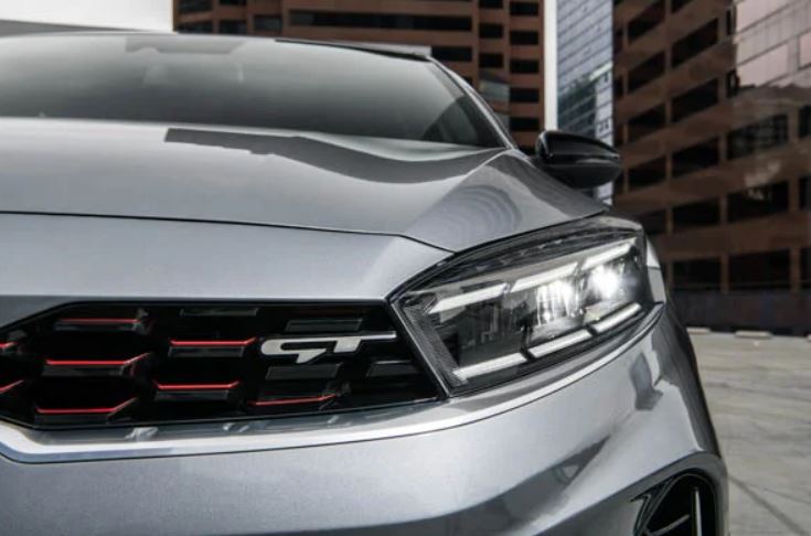 Close view of the headlight and grille area of a silver 2022 Kia Forte. | Kia service in Bentonville, AR.